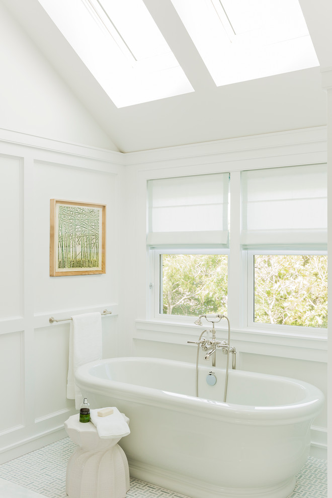 Photo of a beach style master bathroom in Boston with a freestanding tub, white walls and ceramic floors.