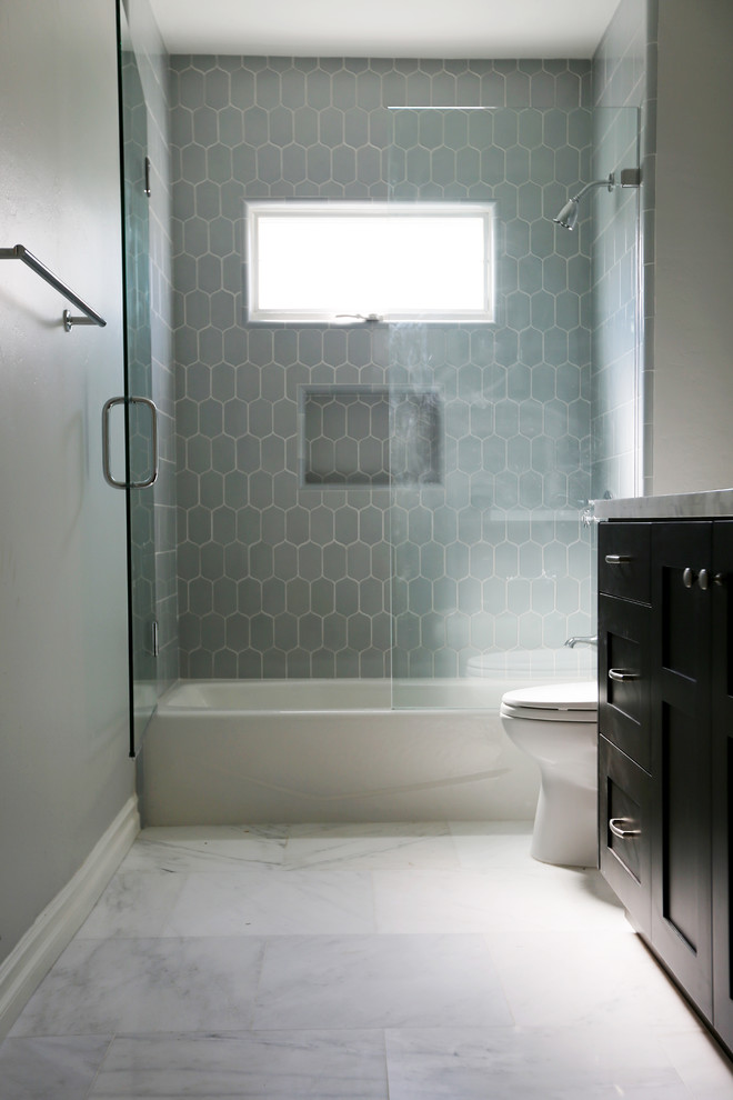This is an example of a mid-sized traditional bathroom in San Diego with shaker cabinets, dark wood cabinets, marble benchtops, blue tile, ceramic tile, an alcove tub, an alcove shower, a two-piece toilet, an undermount sink, white walls and marble floors.