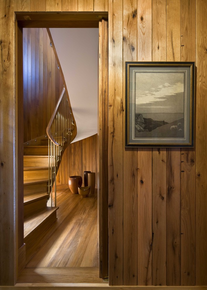 This is an example of a beach style wood curved staircase in Boston with wood risers.