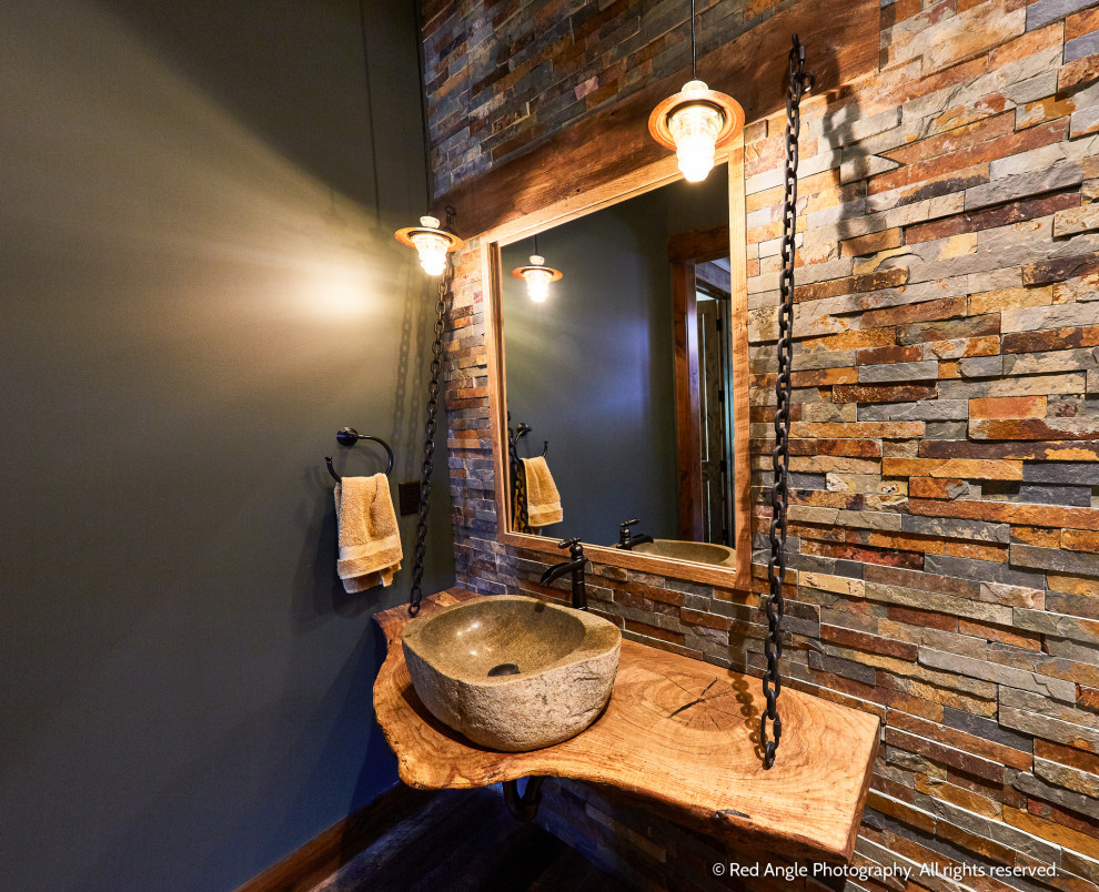 На фото: ванная комната среднего размера в стиле рустика с каменной плиткой, душевой кабиной, настольной раковиной, столешницей из дерева, коричневой столешницей, тумбой под одну раковину и подвесной тумбой с