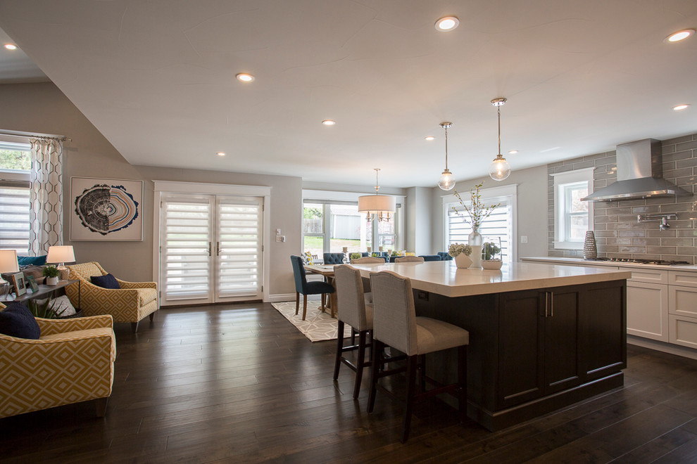 Inspiration for a large transitional l-shaped medium tone wood floor and brown floor eat-in kitchen remodel in Denver with a single-bowl sink, recessed-panel cabinets, white cabinets, quartz countertops, gray backsplash, ceramic backsplash, stainless steel appliances and two islands
