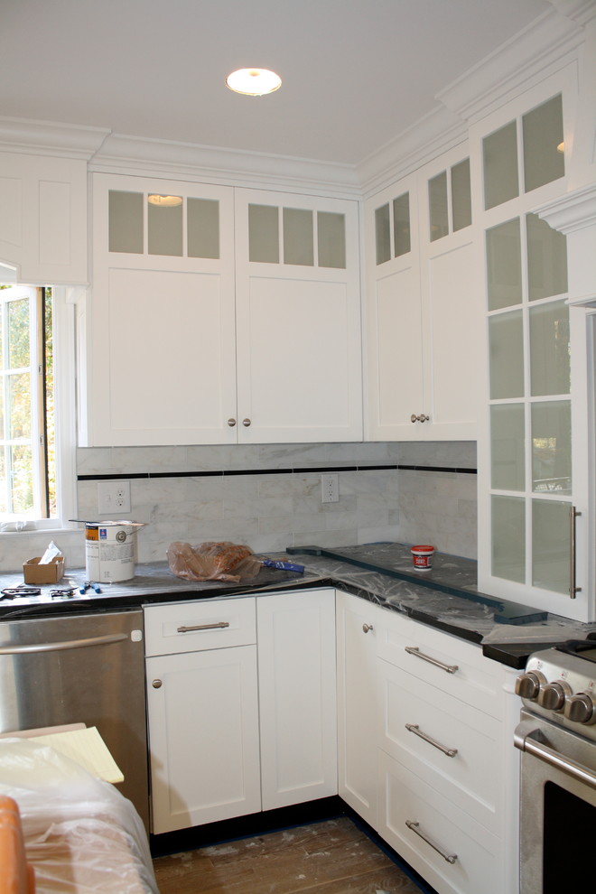 Example of a huge kitchen design in Charlotte with recessed-panel cabinets, white cabinets, granite countertops and stone tile backsplash