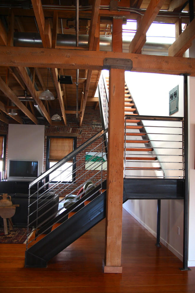 Industrial wood l-shaped staircase in San Francisco with open risers.