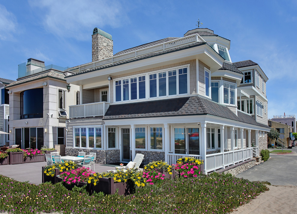Photo of a beach style three-storey exterior in Orange County with wood siding.