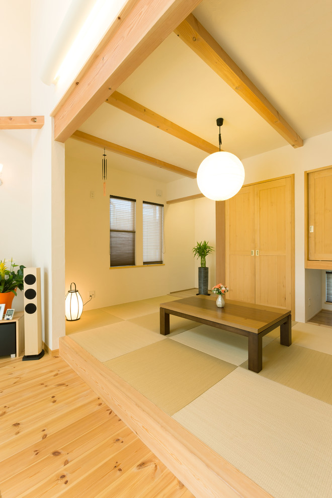 This is an example of an open concept family room in Other with white walls, tatami floors and green floor.