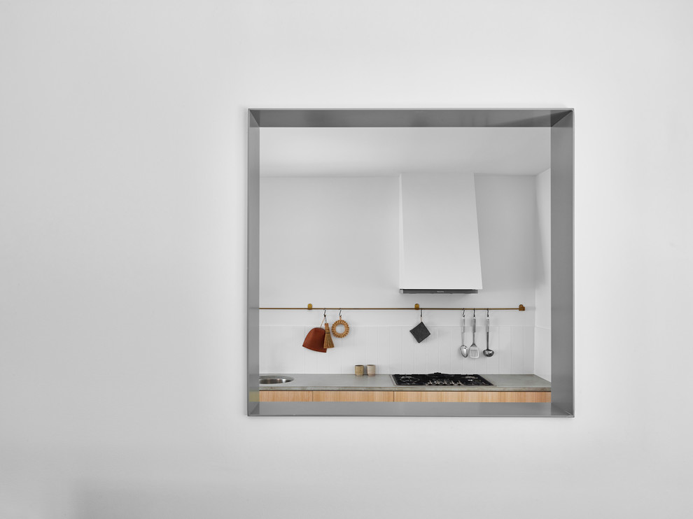 This is an example of a small contemporary galley eat-in kitchen in Brisbane with a double-bowl sink, light wood cabinets, concrete benchtops, white splashback, ceramic splashback, stainless steel appliances, dark hardwood floors and black floor.