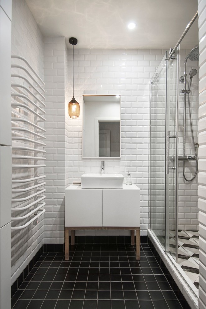 Small scandinavian 3/4 bathroom in Saint Petersburg with flat-panel cabinets, white cabinets, an alcove shower, white tile, black and white tile, black tile, white walls, ceramic floors, subway tile, a vessel sink, black floor and a sliding shower screen.