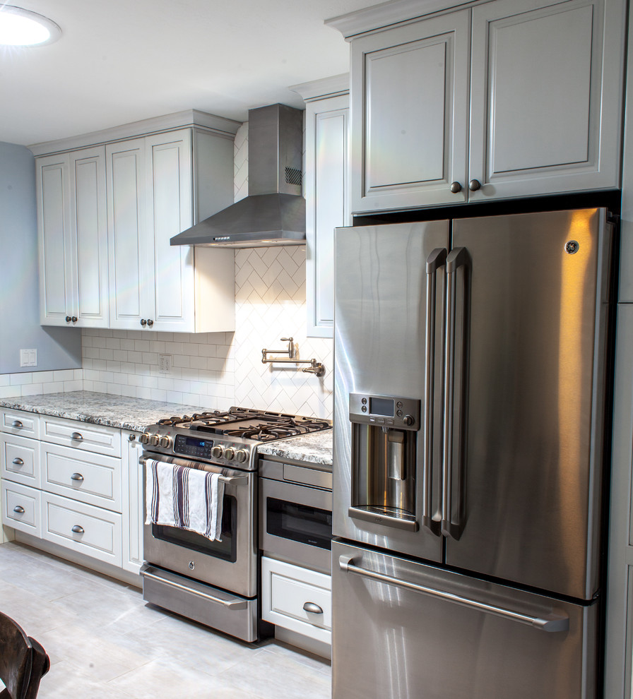 This is an example of a small transitional galley eat-in kitchen in Boise with an undermount sink, raised-panel cabinets, white cabinets, granite benchtops, white splashback, ceramic splashback, stainless steel appliances, ceramic floors and no island.