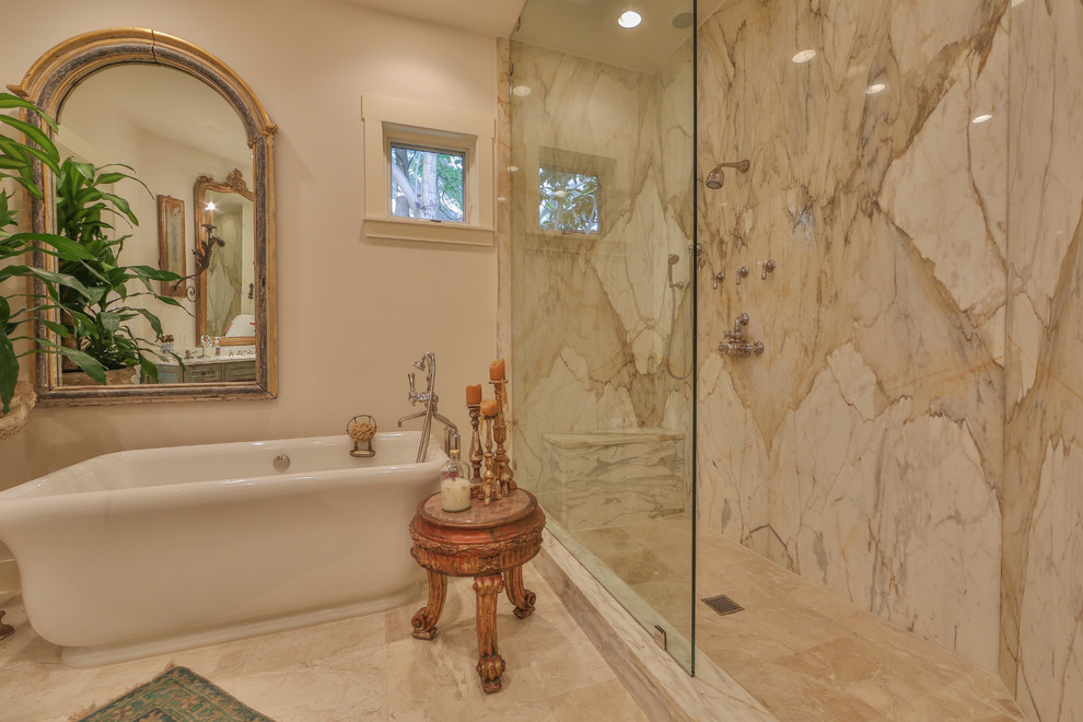 Inspiration for a large modern master bathroom in Austin with a freestanding tub, an alcove shower, beige walls, marble floors, beige floor, a hinged shower door, an undermount sink, furniture-like cabinets, distressed cabinets, white tile, beige tile, gray tile, marble, marble benchtops and a two-piece toilet.