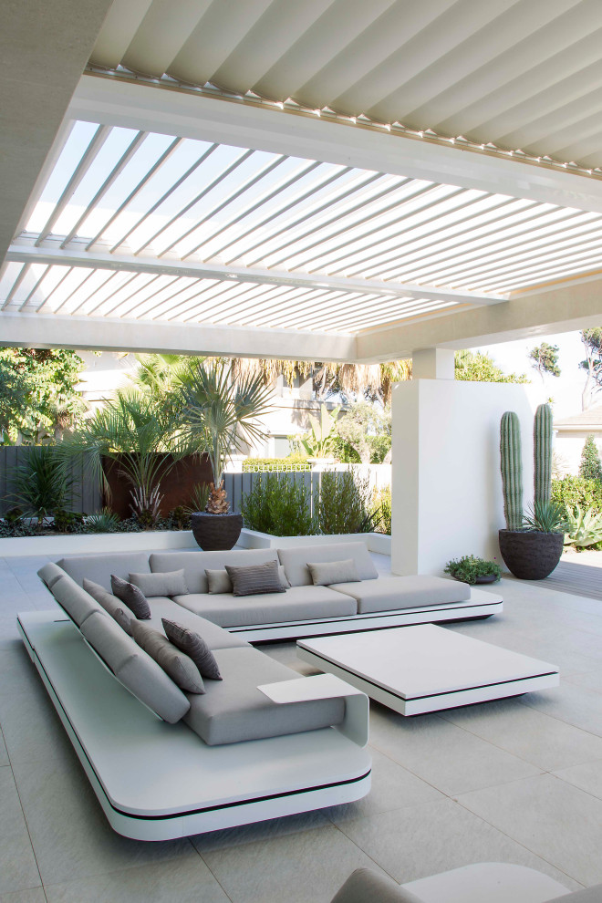 Photo of a large contemporary backyard patio in Other with tile and a pergola.