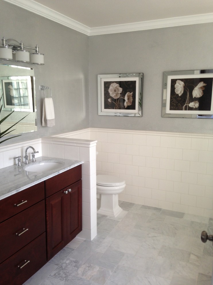 Photo of a mid-sized traditional master bathroom in San Francisco with raised-panel cabinets, dark wood cabinets, a drop-in tub, a corner shower, a two-piece toilet, white tile, ceramic tile, grey walls, an undermount sink, quartzite benchtops, white floor, a hinged shower door and white benchtops.