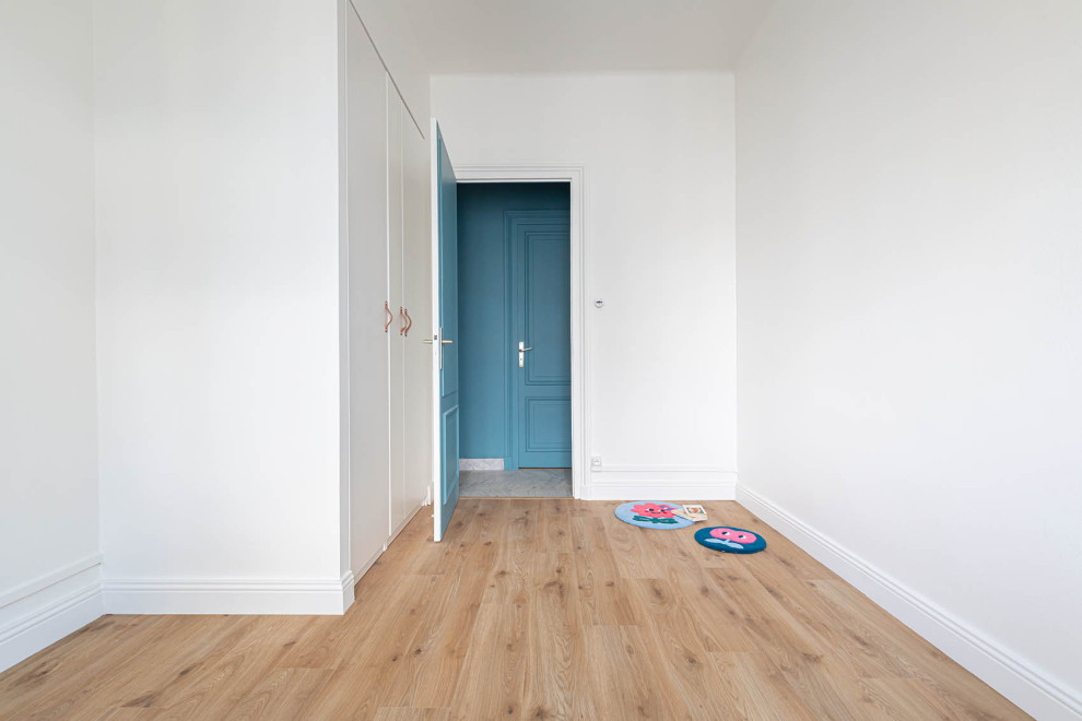 Réalisation d'une chambre design avec un mur gris et parquet foncé.