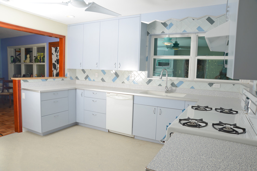 Inspiration for a mid-sized midcentury u-shaped eat-in kitchen in Miami with an integrated sink, flat-panel cabinets, laminate benchtops, glass tile splashback, blue cabinets, beige splashback, linoleum floors, no island and beige floor.