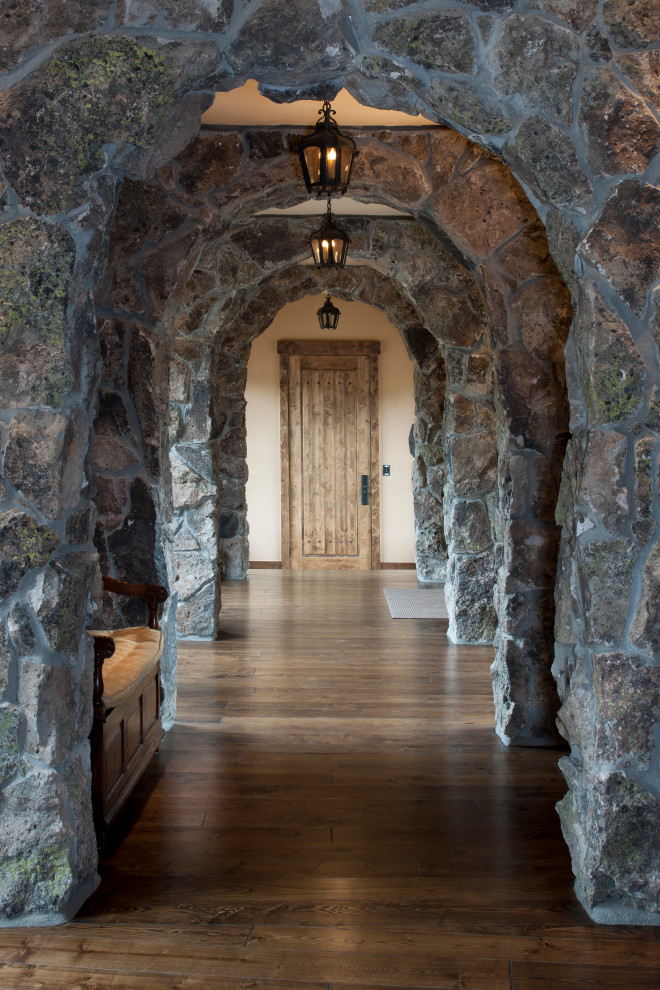 Inspiration for a rustic dark wood floor and brown floor hallway remodel in Denver with brown walls