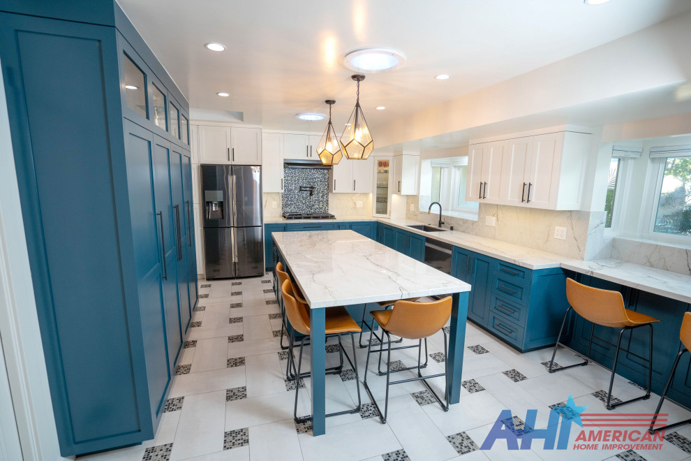 Foto på ett mellanstort funkis vit kök, med en nedsänkt diskho, luckor med upphöjd panel, blå skåp, marmorbänkskiva, vitt stänkskydd, stänkskydd i marmor, rostfria vitvaror, klinkergolv i porslin, en köksö och flerfärgat golv
