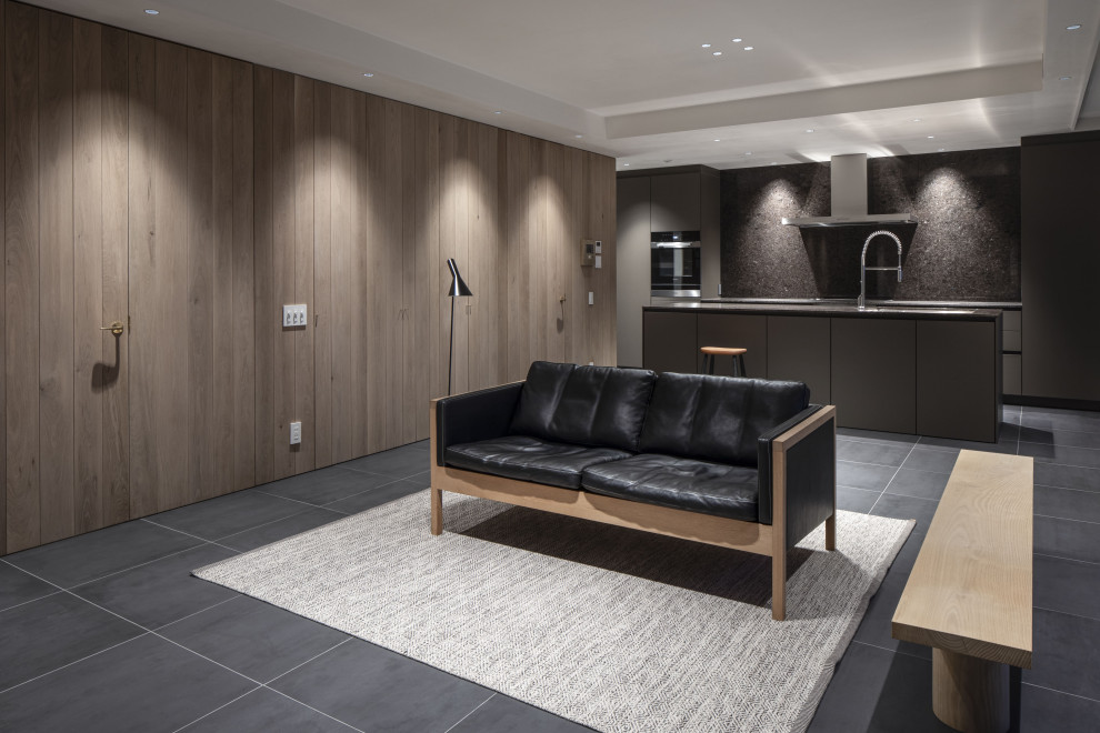 This is an example of a mid-sized modern open concept living room in Nagoya with a home bar, white walls, ceramic floors, no fireplace, a wall-mounted tv, black floor, timber and decorative wall panelling.