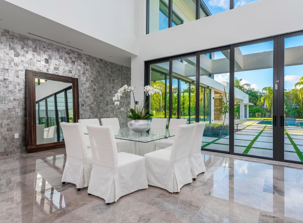 This is an example of a large contemporary open plan dining in Miami with white walls, no fireplace, grey floor and ceramic floors.