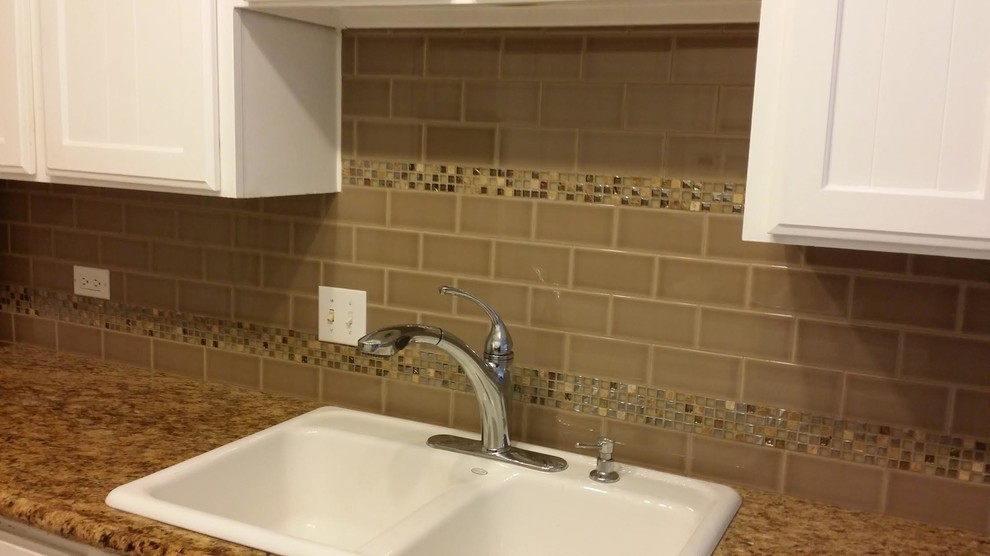 Example of a mid-sized transitional galley enclosed kitchen design in Phoenix with a drop-in sink, recessed-panel cabinets, white cabinets, granite countertops, beige backsplash, subway tile backsplash and an island
