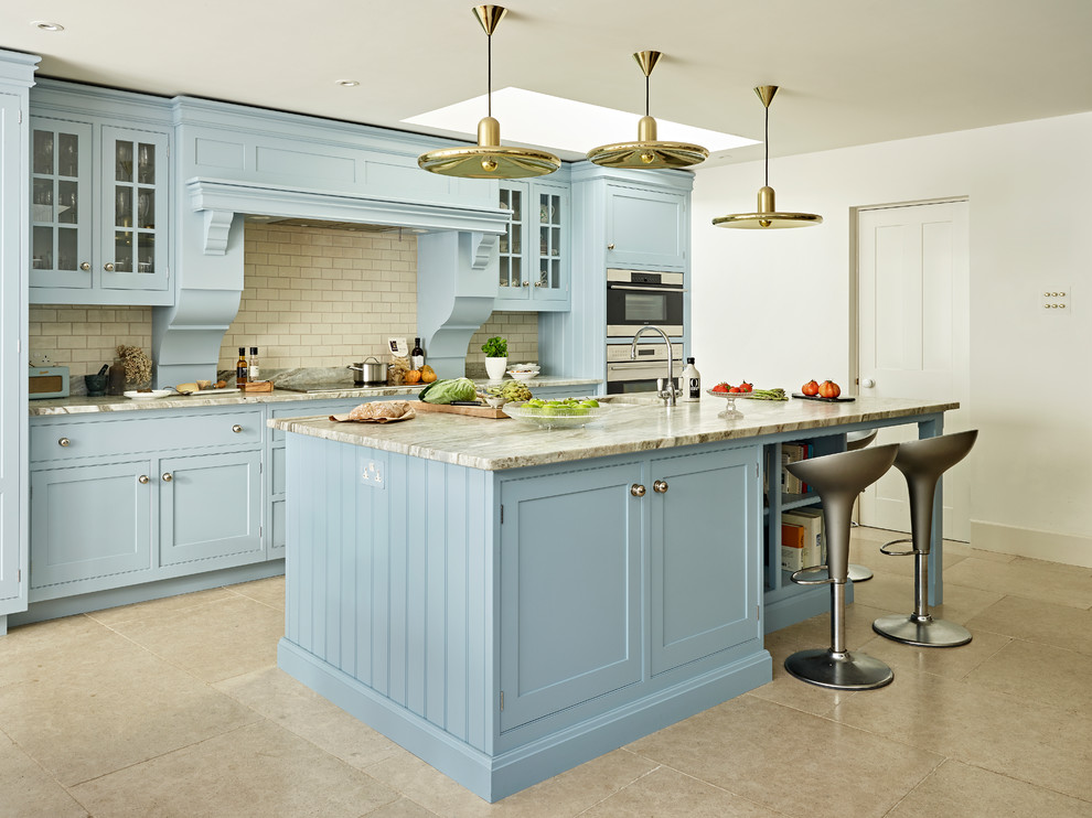 Large traditional single-wall open plan kitchen in Oxfordshire with a single-bowl sink, shaker cabinets, blue cabinets, granite benchtops, stainless steel appliances, with island, white splashback, subway tile splashback, grey floor and grey benchtop.