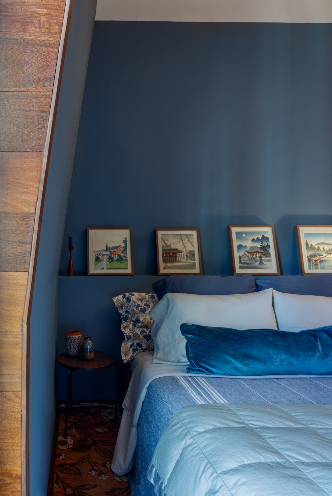 Idée de décoration pour une chambre parentale design de taille moyenne avec un mur bleu.