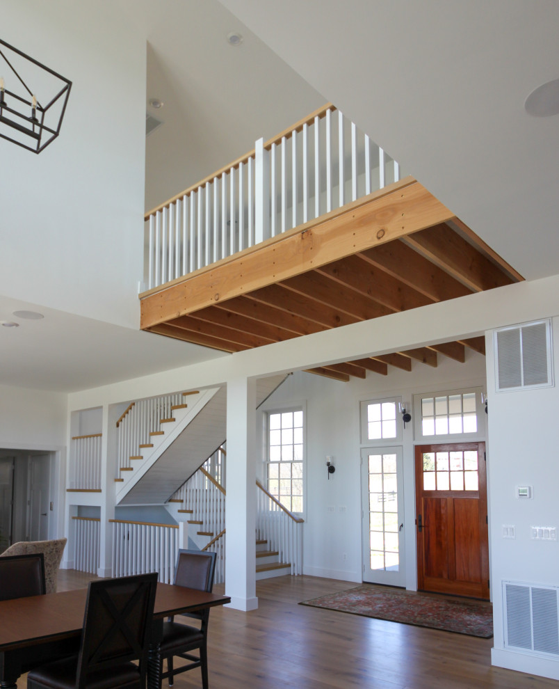 Photo of a mid-sized country wood u-shaped staircase in DC Metro with wood risers, wood railing and planked wall panelling.
