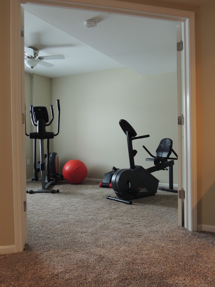 This is an example of a small traditional home gym in Detroit with beige walls and carpet.
