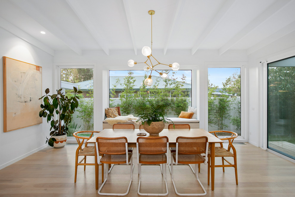 Classic open plan dining room in Melbourne with medium hardwood flooring, no fireplace, brown floors and exposed beams.