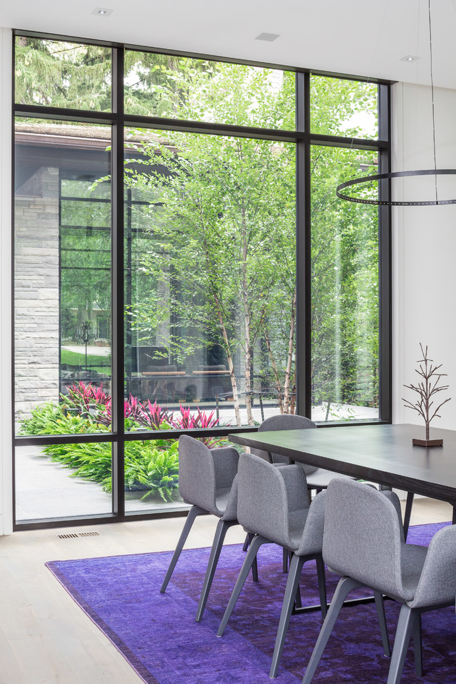 Photo of a modern open plan dining in Toronto with white walls and light hardwood floors.