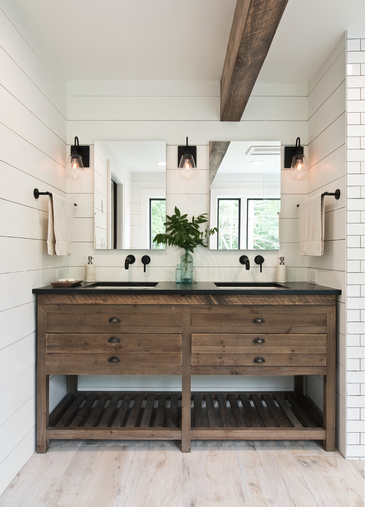 Mid-sized country master bathroom in New York with dark wood cabinets, a freestanding tub, a curbless shower, white tile, subway tile, white walls, light hardwood floors, an undermount sink, beige floor, an open shower, black benchtops and open cabinets.