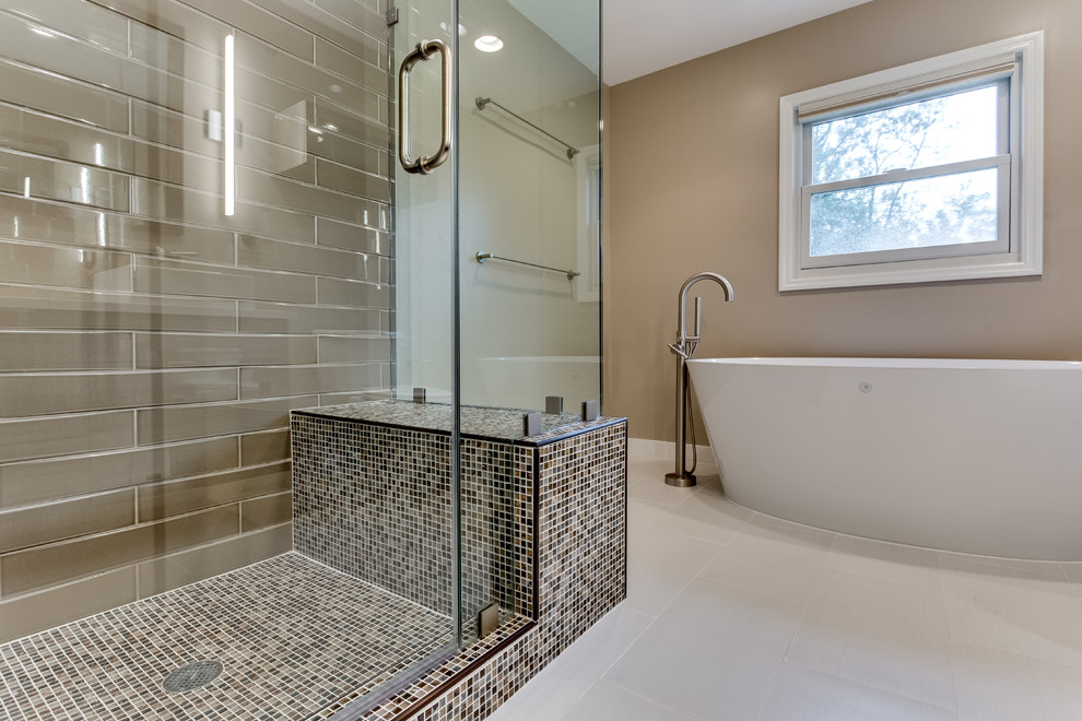 This is an example of a large transitional master bathroom in DC Metro with engineered quartz benchtops, a freestanding tub and a wall-mount toilet.
