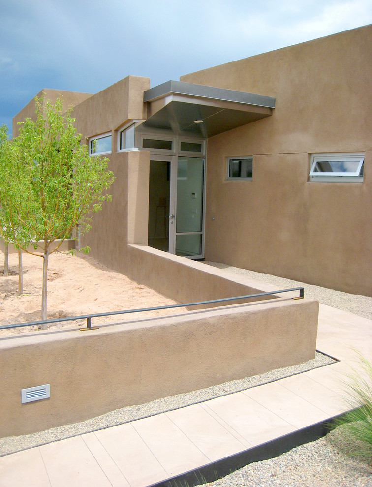 Inspiration for a mid-sized contemporary front door in Albuquerque with beige walls and a glass front door.