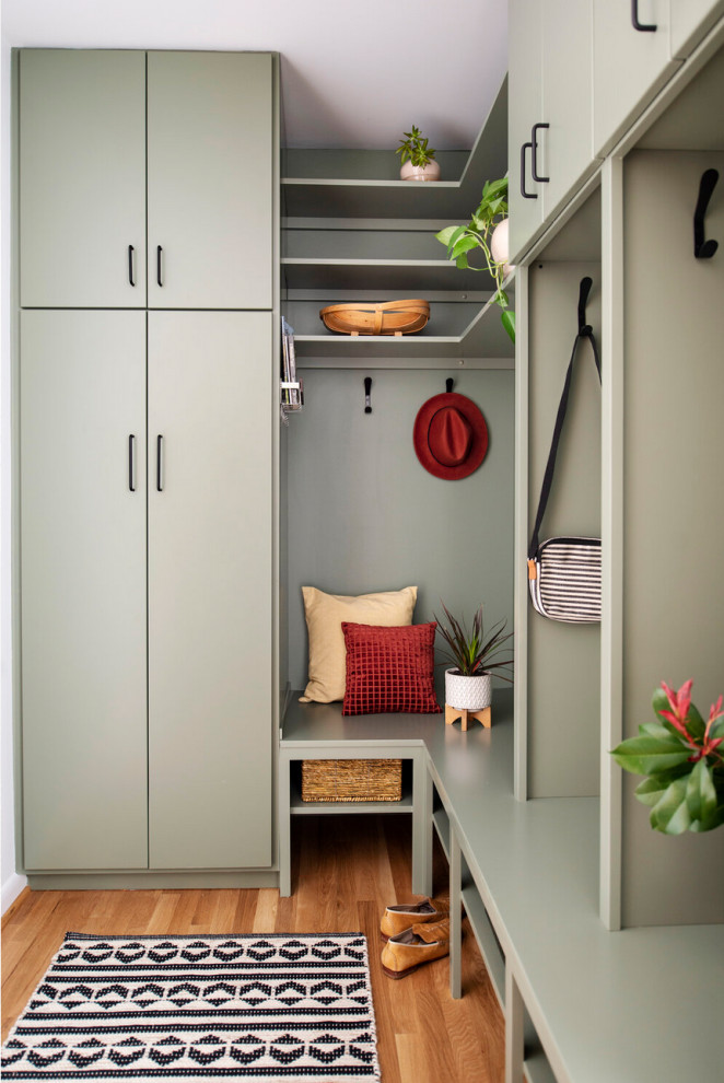 Design ideas for a small contemporary mudroom in Raleigh with green walls, medium hardwood floors and brown floor.