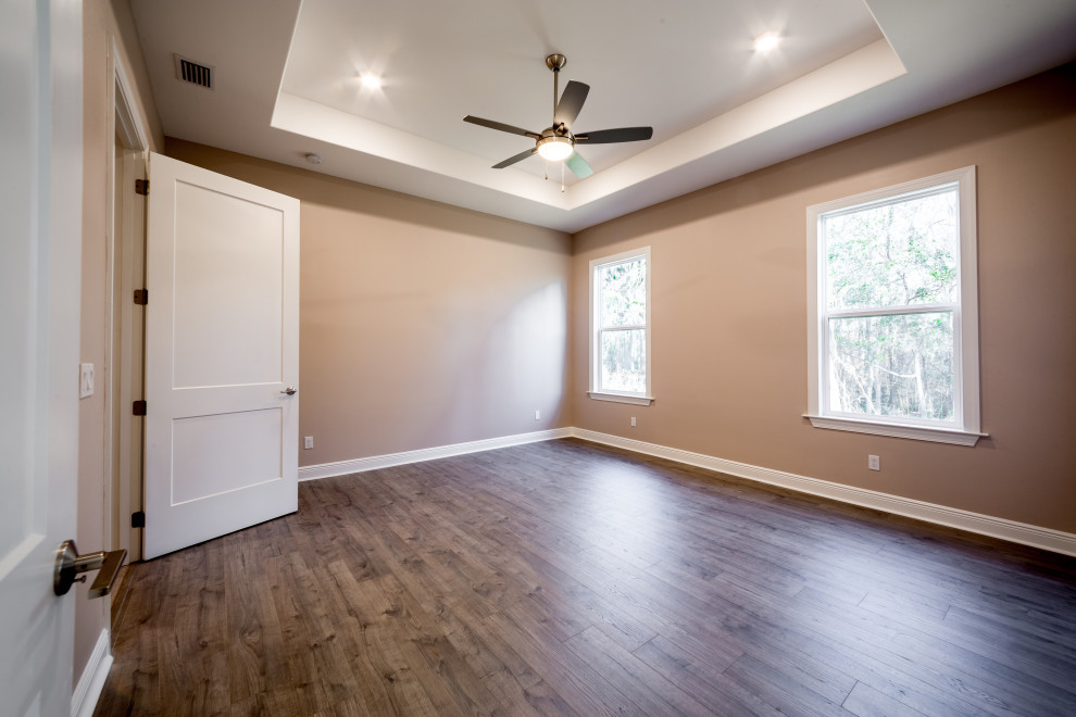 Réalisation d'une chambre parentale tradition de taille moyenne avec un mur beige, un sol en vinyl, un sol marron et un plafond décaissé.