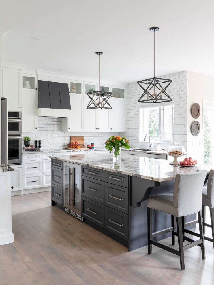 Design ideas for a large transitional u-shaped eat-in kitchen in Calgary with an undermount sink, shaker cabinets, white cabinets, granite benchtops, white splashback, subway tile splashback, stainless steel appliances, medium hardwood floors, with island, grey floor and grey benchtop.