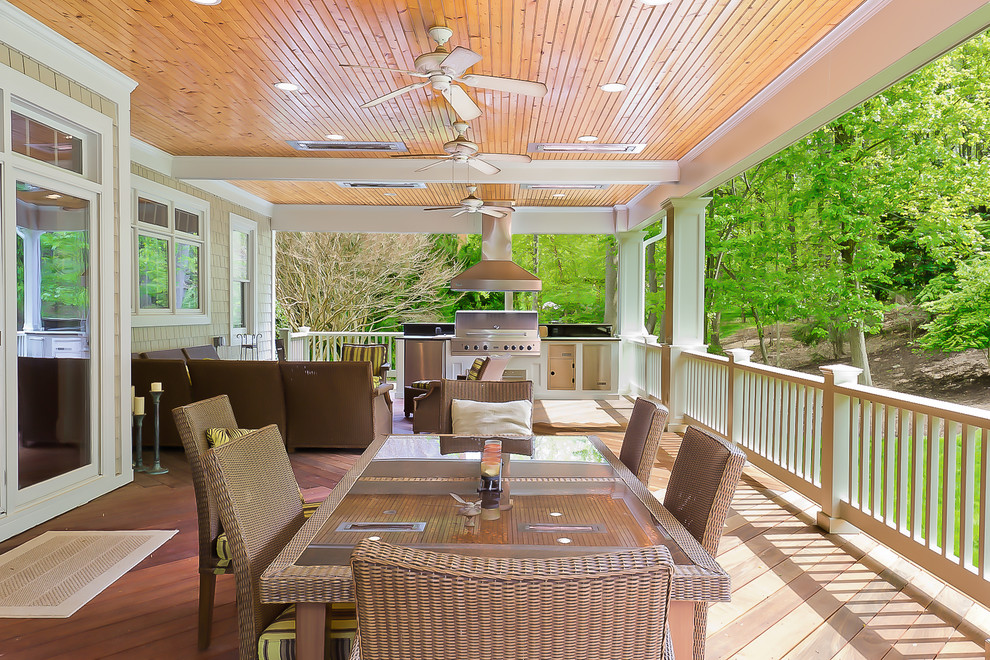 Large traditional backyard deck in DC Metro with an outdoor kitchen and a roof extension.