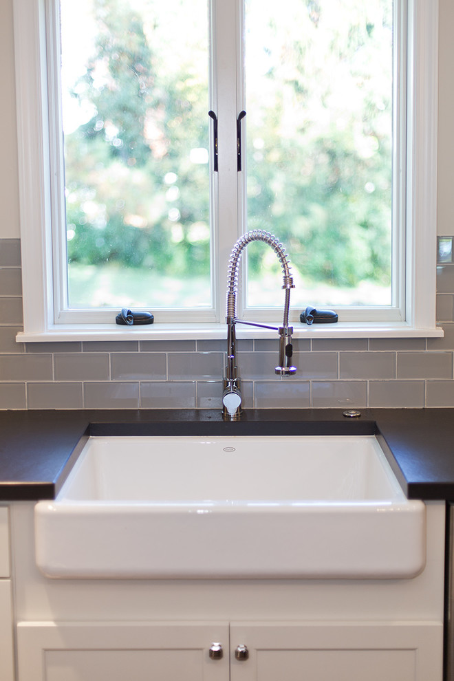 Example of a large mountain style u-shaped dark wood floor eat-in kitchen design in DC Metro with a farmhouse sink, shaker cabinets, light wood cabinets, quartz countertops, gray backsplash, glass tile backsplash, stainless steel appliances and an island