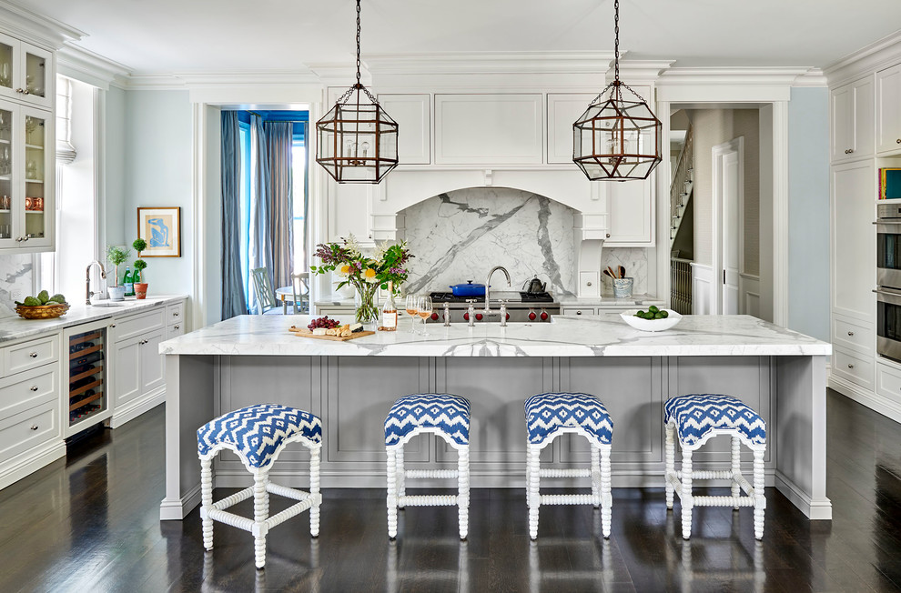 Inspiration for a large transitional u-shaped dark wood floor and brown floor open concept kitchen remodel in Chicago with a farmhouse sink, shaker cabinets, white cabinets, marble countertops, white backsplash, marble backsplash, stainless steel appliances and an island