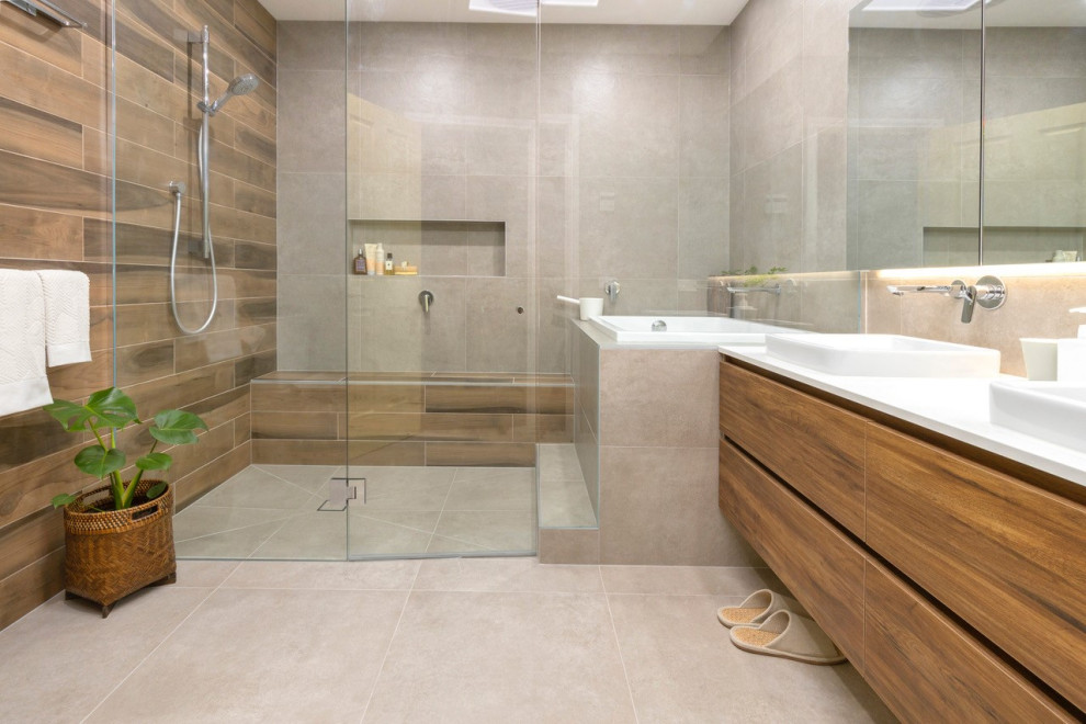 Large contemporary master wet room bathroom in Melbourne with beige tile, porcelain tile, porcelain floors, engineered quartz benchtops, beige floor, flat-panel cabinets, medium wood cabinets, a vessel sink, white benchtops, a japanese tub, an open shower, a shower seat, a double vanity and a floating vanity.