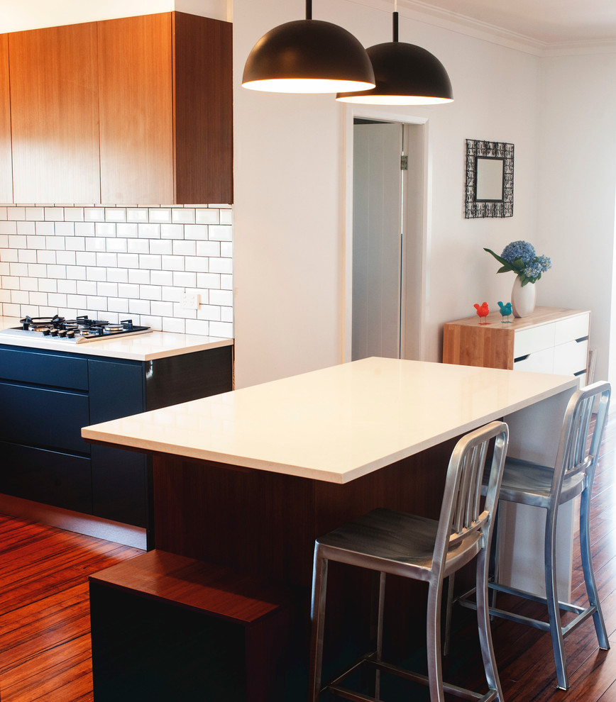 Photo of a large modern u-shaped open plan kitchen in Sydney with a drop-in sink, recessed-panel cabinets, black cabinets, white splashback, subway tile splashback, stainless steel appliances and with island.