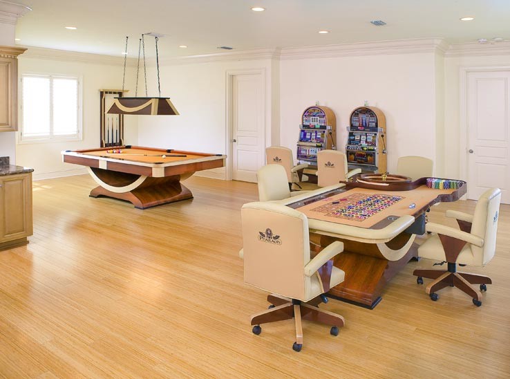 This is an example of a large contemporary loft-style family room in Los Angeles with a game room, white walls and light hardwood floors.