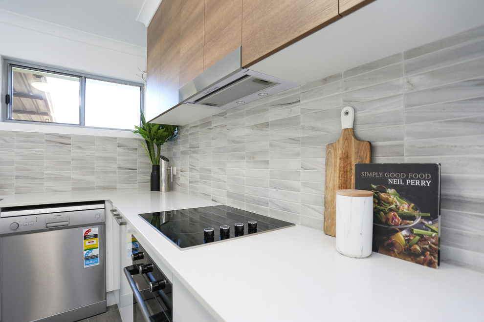 Inspiration for a small scandinavian l-shaped kitchen pantry with an undermount sink, flat-panel cabinets, white cabinets, quartz benchtops, multi-coloured splashback, mosaic tile splashback, stainless steel appliances, ceramic floors, a peninsula and grey floor.