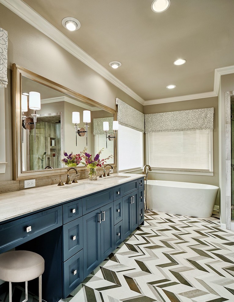 Design ideas for a mid-sized transitional master bathroom in Dallas with recessed-panel cabinets, blue cabinets, a freestanding tub, beige walls, an undermount sink, a two-piece toilet, black and white tile, gray tile, mosaic tile, linoleum floors, granite benchtops and beige benchtops.