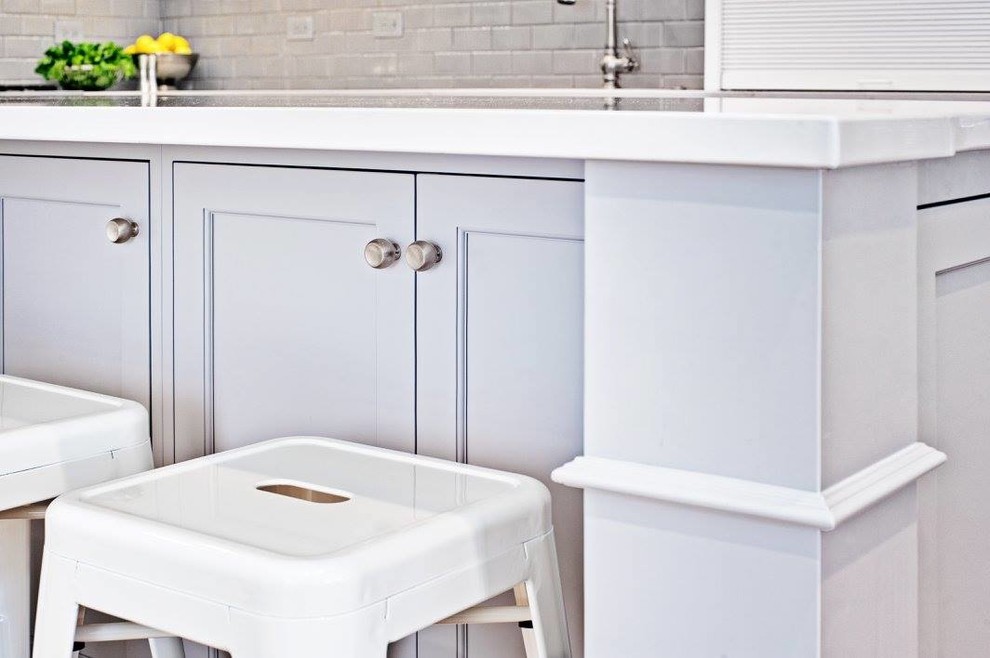 Kitchen - mid-sized transitional l-shaped light wood floor and beige floor kitchen idea in Chicago with an undermount sink, shaker cabinets, white cabinets, quartzite countertops, gray backsplash, subway tile backsplash, stainless steel appliances and an island