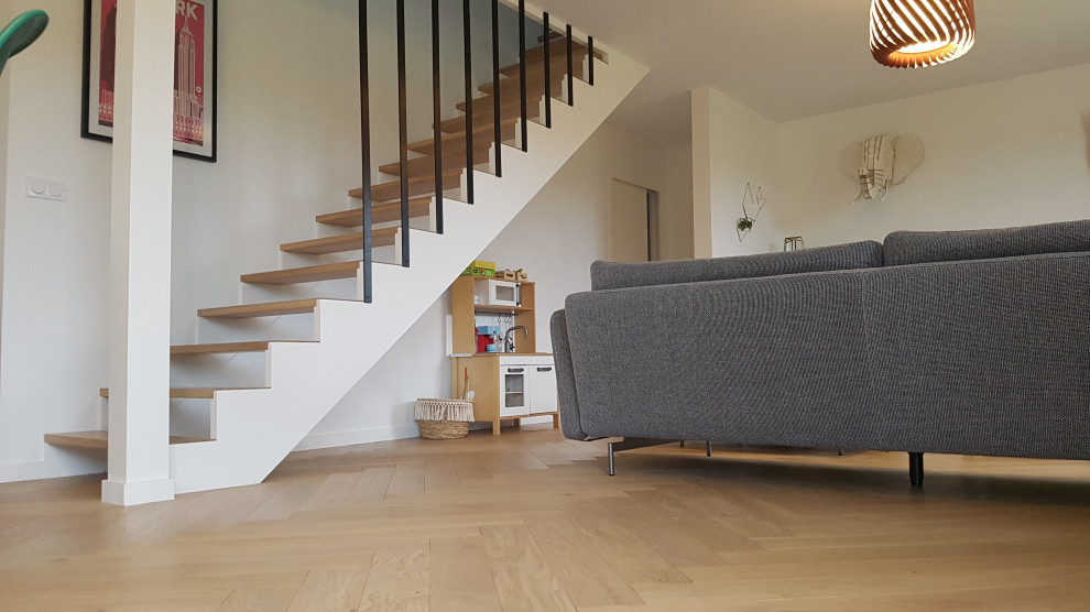 This is an example of an expansive contemporary wood straight staircase in Rennes with open risers and metal railing.