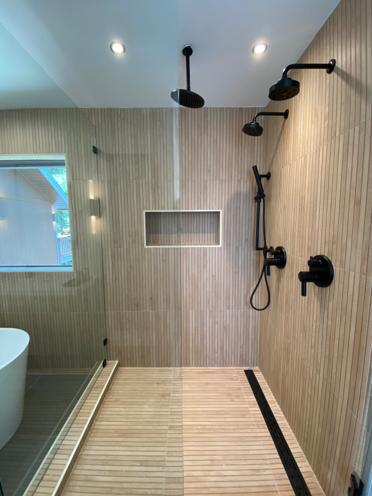 Photo of a large scandinavian master bathroom in Other with flat-panel cabinets, beige cabinets, a freestanding tub, an open shower, a bidet, white tile, porcelain tile, white walls, porcelain floors, a wall-mount sink, solid surface benchtops, black floor, a hinged shower door, white benchtops, a double vanity and a floating vanity.