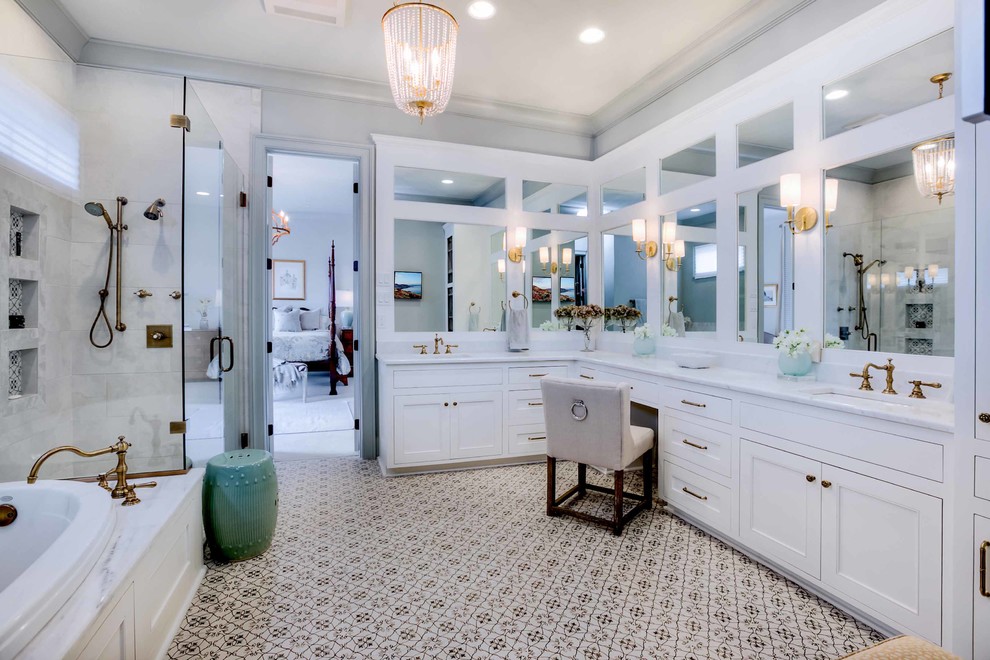 Design ideas for a mid-sized transitional master bathroom in New Orleans with beaded inset cabinets, white cabinets, a drop-in tub, a corner shower, a one-piece toilet, gray tile, ceramic tile, porcelain floors, an undermount sink, marble benchtops, multi-coloured floor, a hinged shower door and white benchtops.