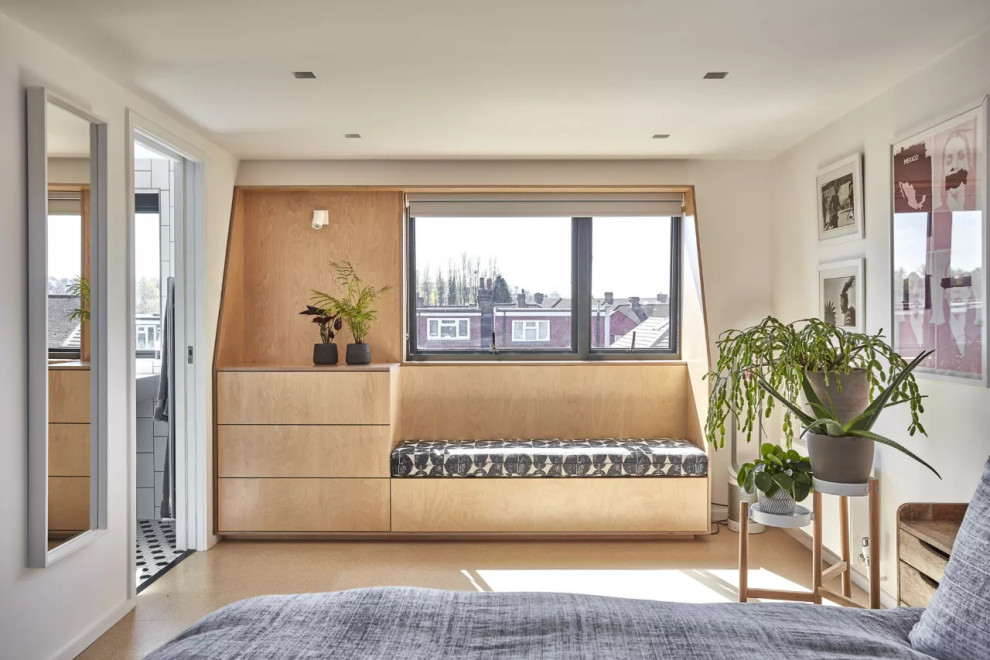 Свежая идея для дизайна: маленькая хозяйская спальня на мансарде в стиле модернизм с бежевыми стенами, полом из ламината, коричневым полом и кирпичными стенами для на участке и в саду - отличное фото интерьера