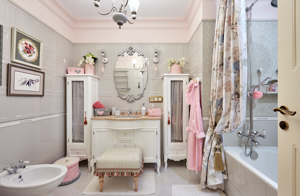 Photo of a bathroom in Other with recessed-panel cabinets, white cabinets, an alcove tub, a shower/bathtub combo, gray tile, pink walls, an undermount sink, grey floor, a shower curtain, beige benchtops, a single vanity, a freestanding vanity and panelled walls.