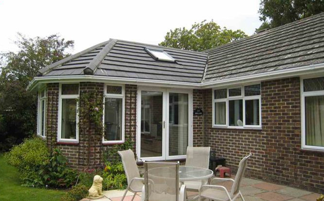 Small modern one-storey brick brown exterior in Sussex with a hip roof.