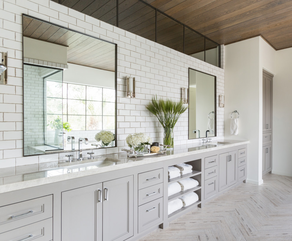 Photo of a large transitional master bathroom in Houston with shaker cabinets, an undermount tub, an open shower, white tile, subway tile, white walls, travertine floors, an undermount sink, marble benchtops, grey floor, a hinged shower door, white benchtops, an enclosed toilet, a double vanity, a built-in vanity and wood.